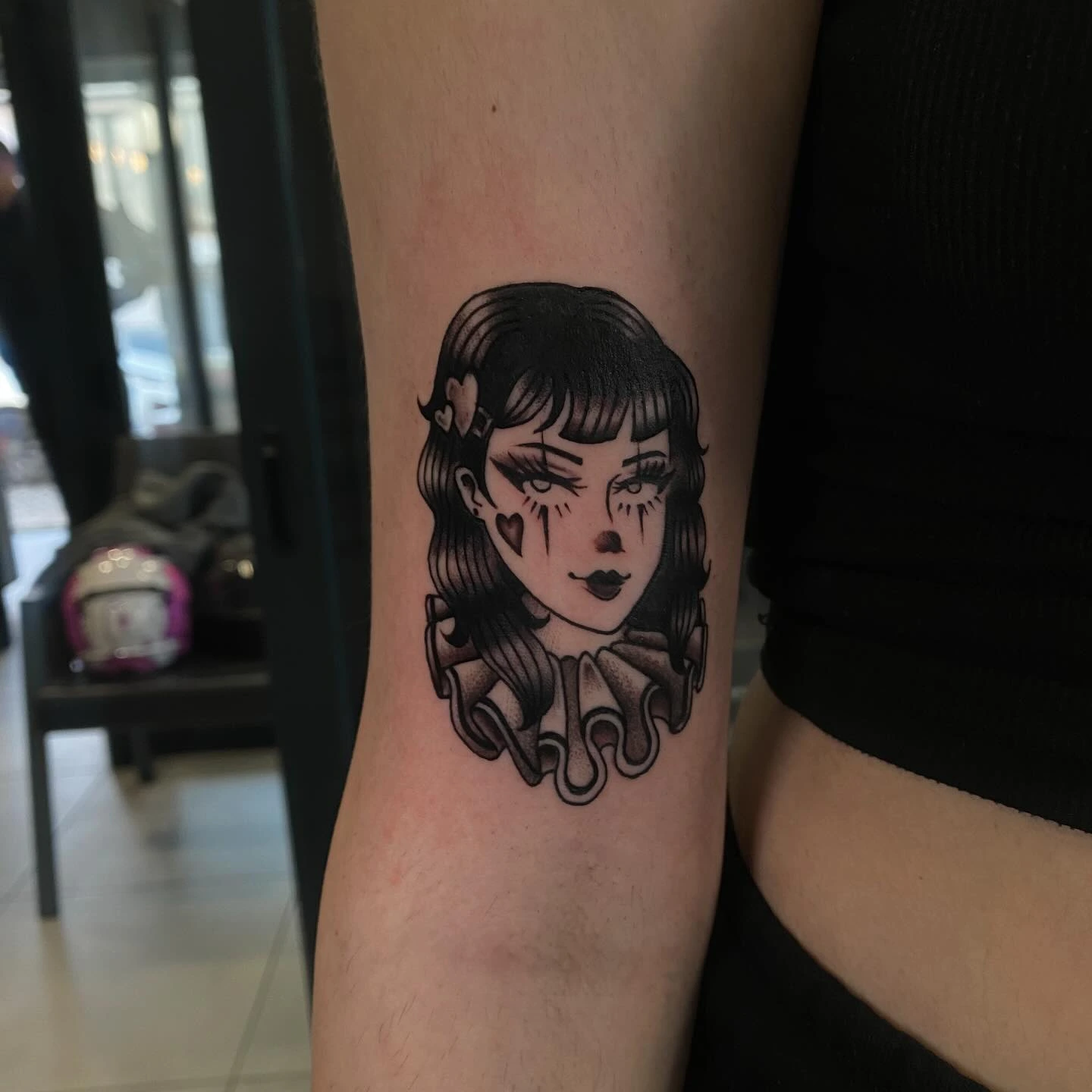 Pin-up clown girl with ruff collar, heart-shaped cheek mark, smudged makeup