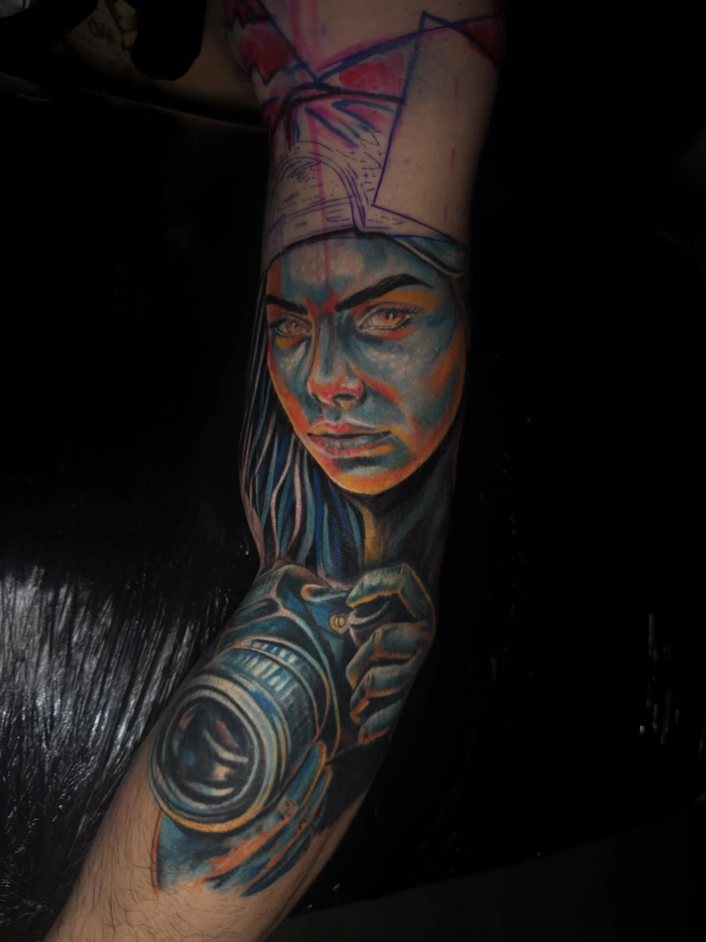 Cool-toned woman portrait with Egyptian-style headdress (blue/orange palette) holding a camera, sketchbook overlay accents