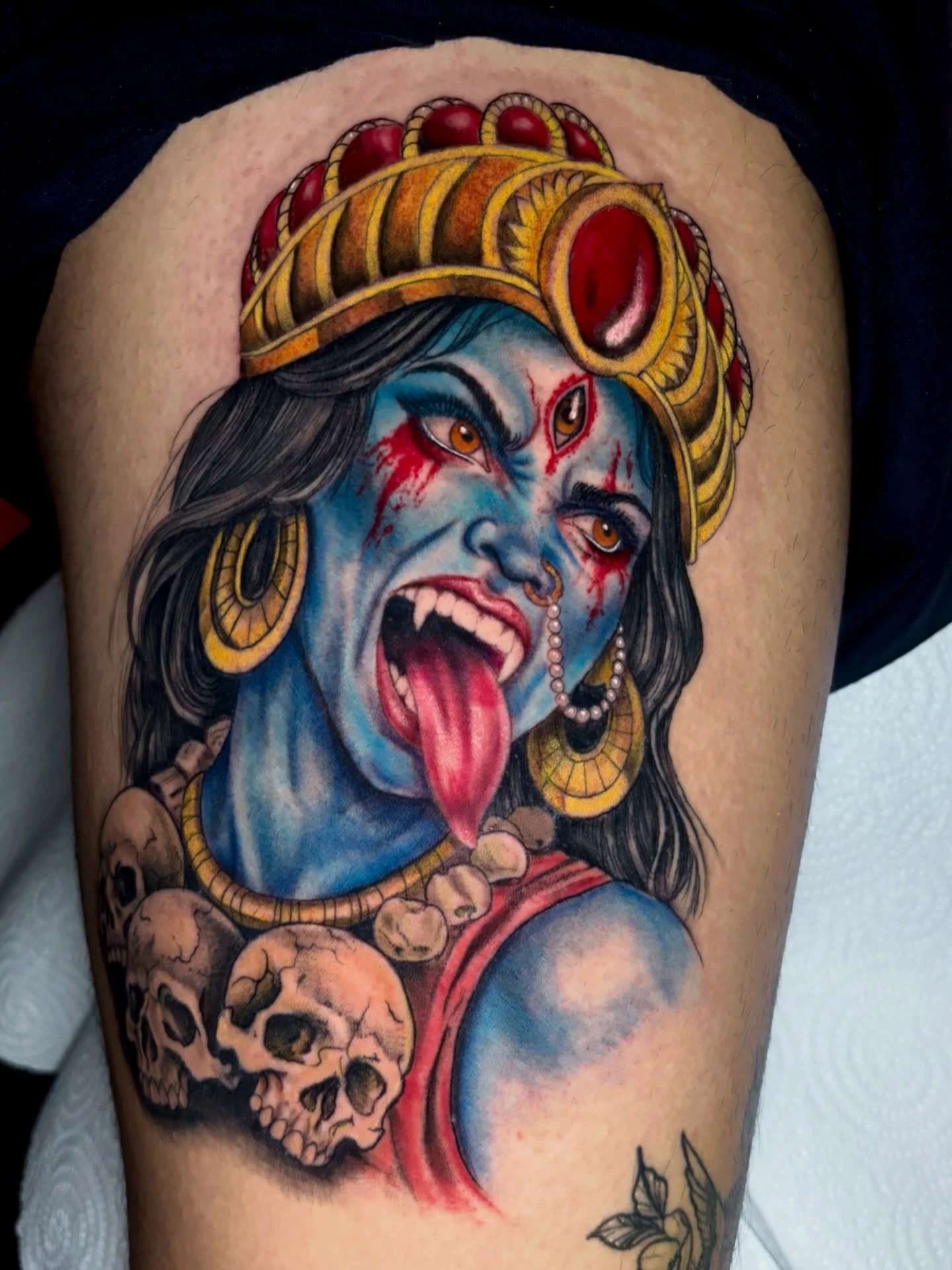 Goddess Kali with blue skin, gold crown, skull necklace, red kimono