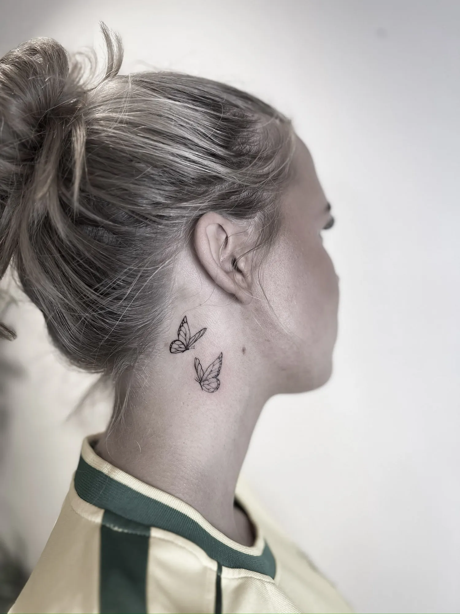 two tiny fineline butterflies on the side of the neck just below and behind the ear