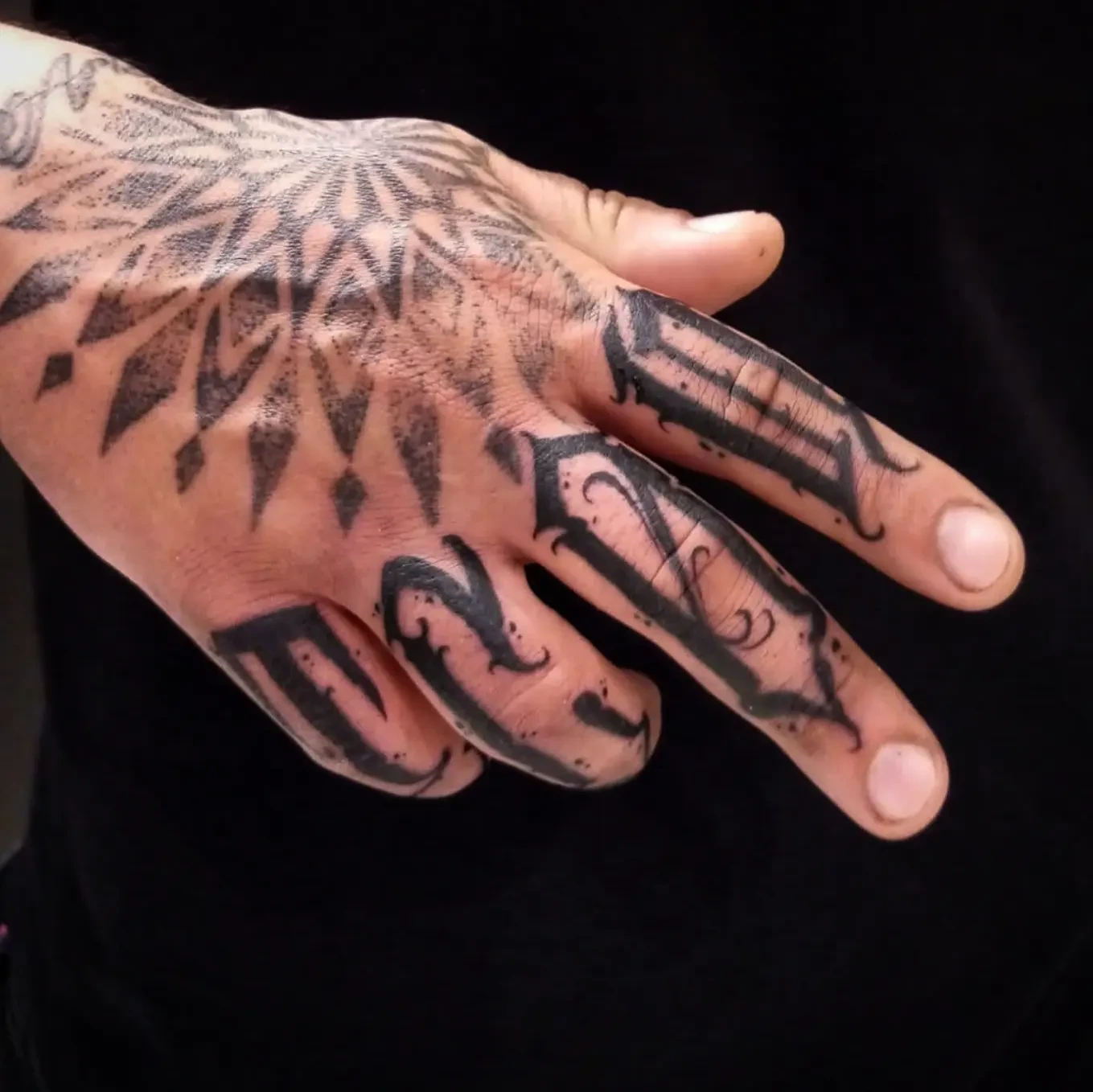 Mandala starburst on hand back + Old English finger letters