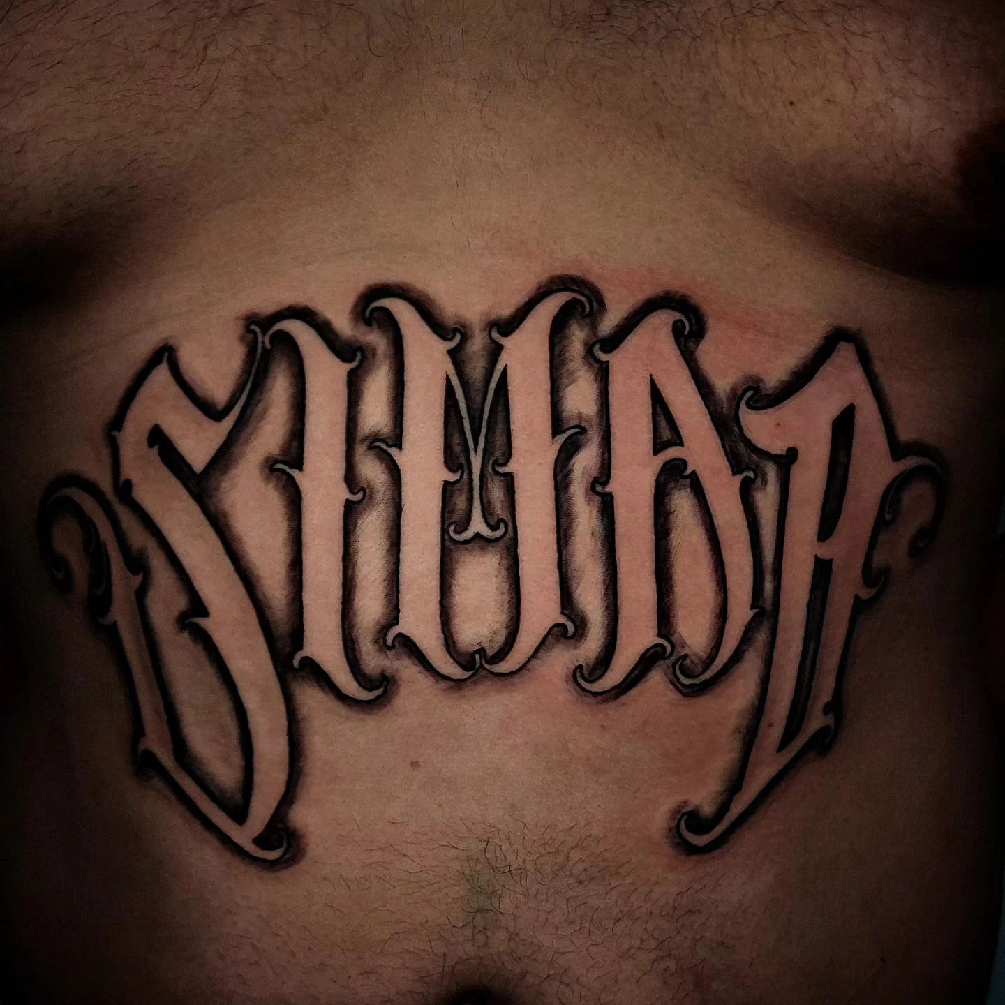 Heavy block dimensional chicano word ('DIVAA' or similar) on stomach