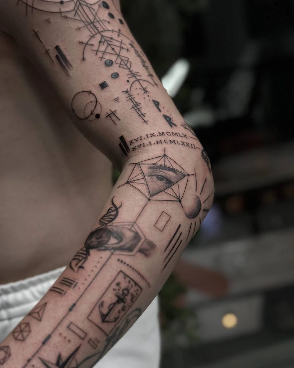 Fineline arm composition, Roman numerals, all-seeing eye triangle, geometric symbols, runes and anchor