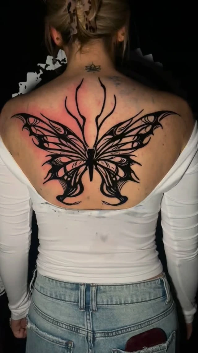 Large stylised tribal butterfly with wing tendrils, solid black