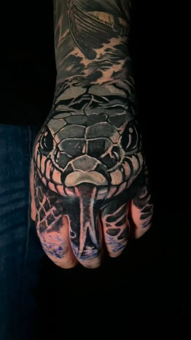 Photoreal snake head with split tongue on hand, snake body wrapping wrist
