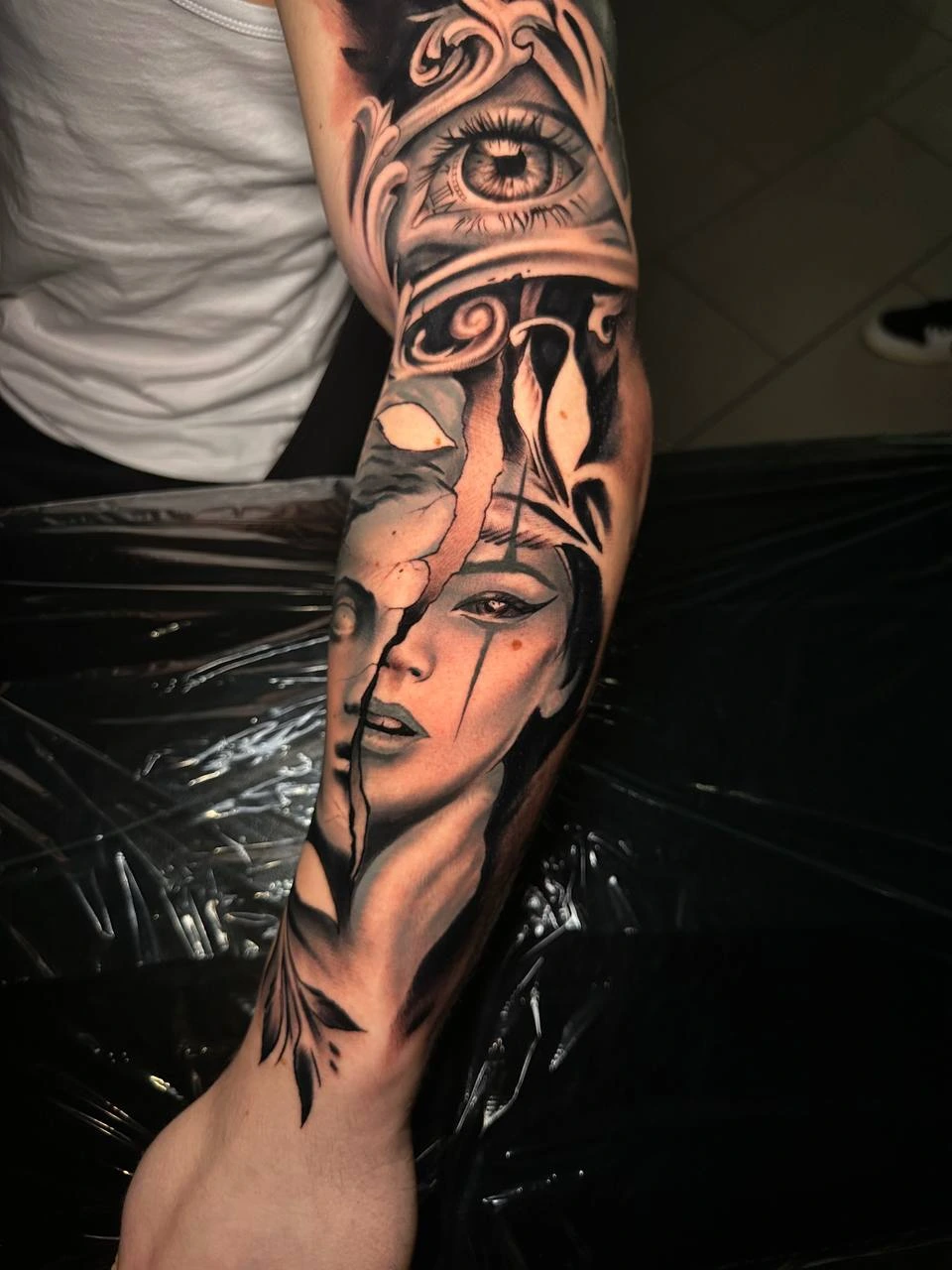 Baroque ornamental eye above a cracked-stone woman portrait, full sleeve