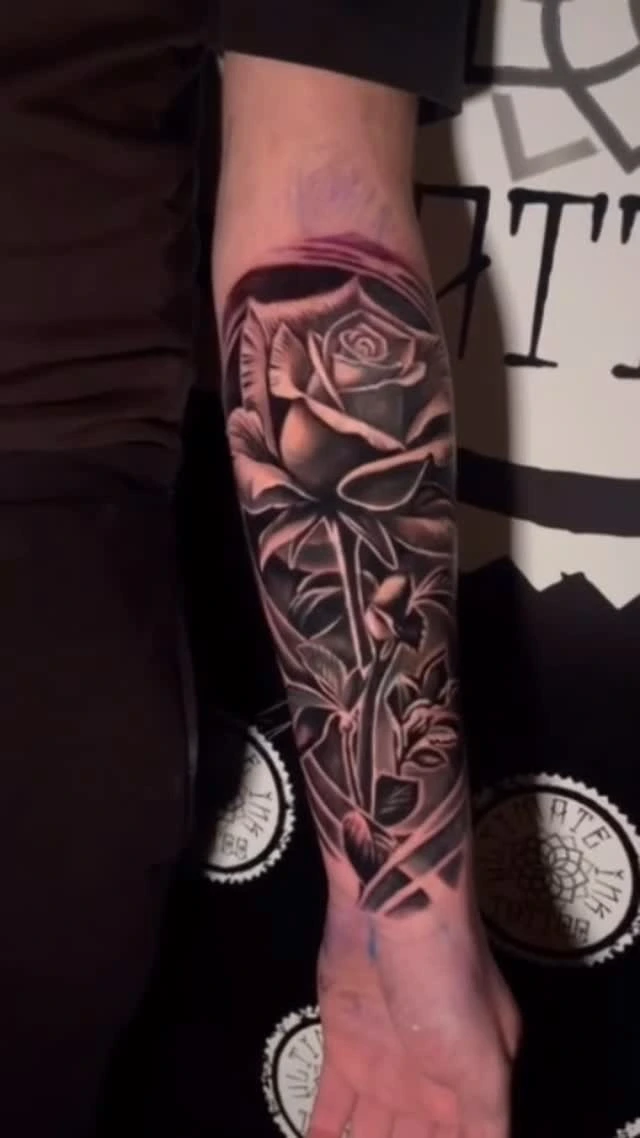 rose with thorny stem inside diamond/coffin frame, forearm sleeve