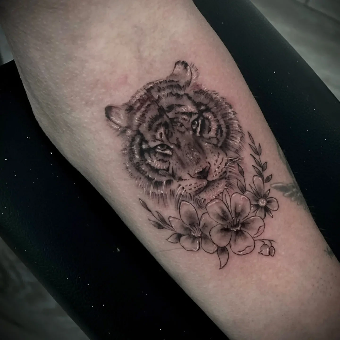 fineline tiger face peeking through flowers