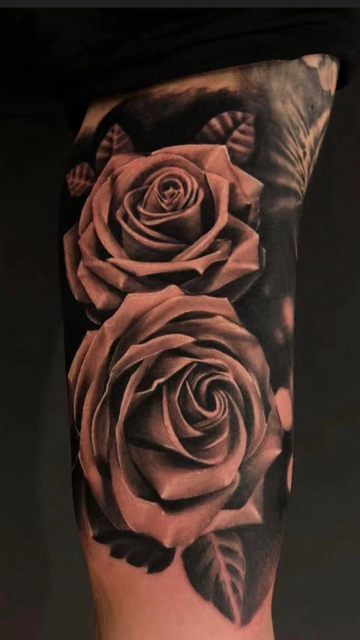 Two photoreal black-and-grey roses on upper arm
